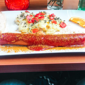 Currywurst with potato salad on a china plate