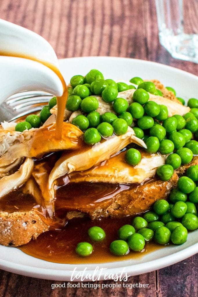 close up shot of Gravy pouring on hot turkey sandwich with peas