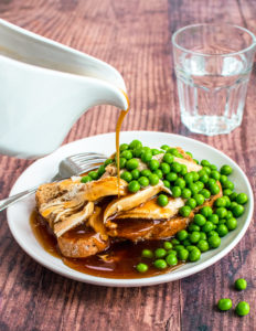 Gravy pouring on hot turkey sandwich with peas