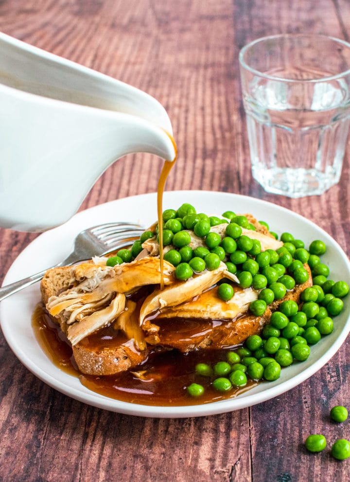 Gravy pouring on hot turkey sandwich with peas