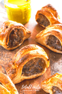 English sausage rolls side shot on serving board with dipping sauce