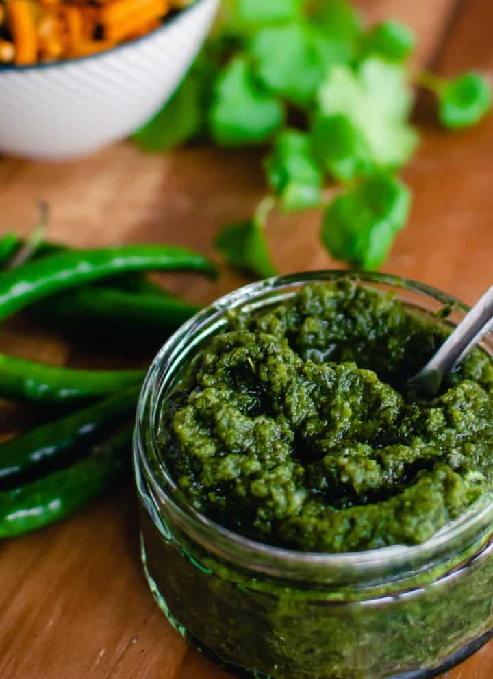 cilantro mint chutney in a glass bowl with spoon