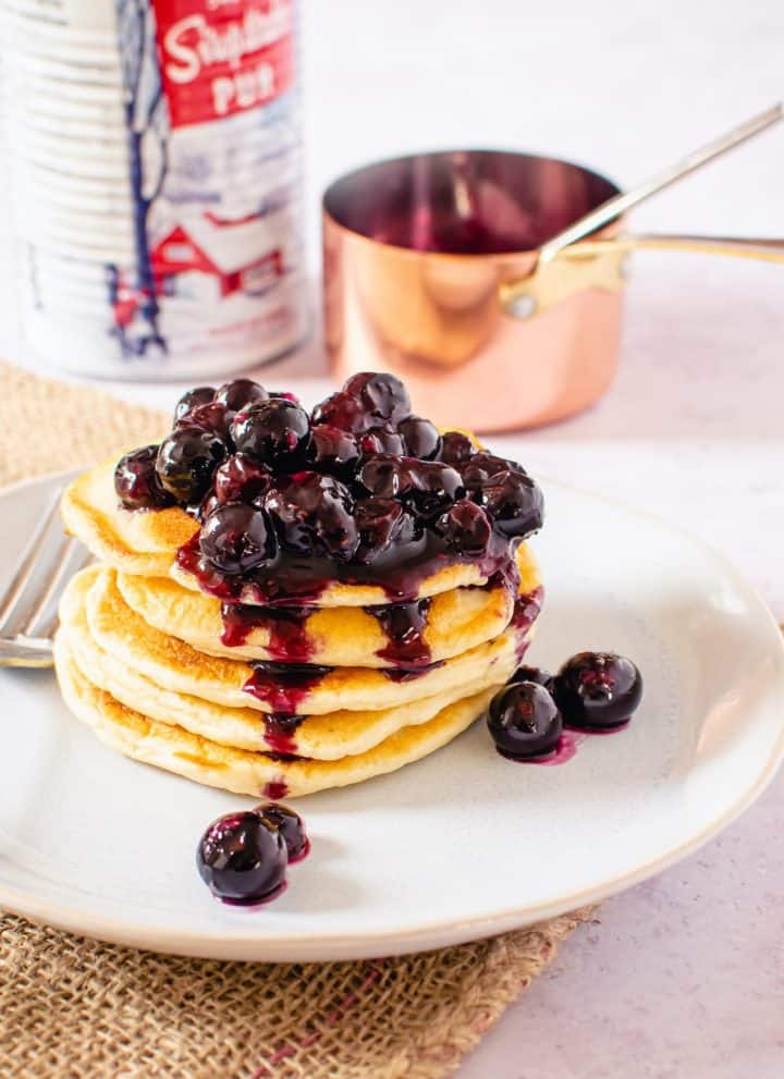 blueberry maple sauce on top of a stack of pancakes