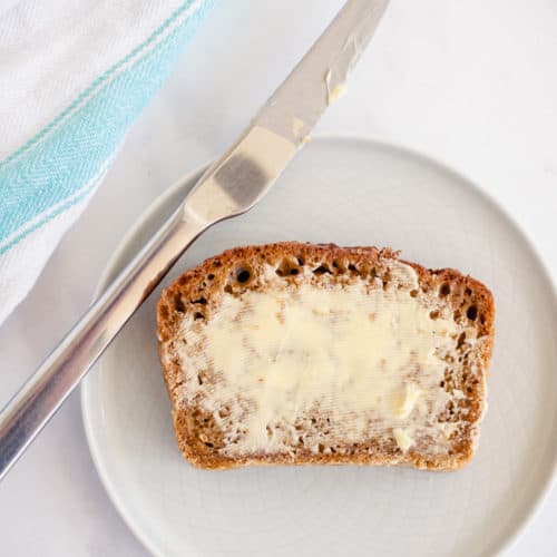 top down picture of oatmeal molasses bread spread with butter