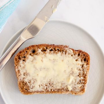 top down picture of oatmeal molasses bread spread with butter